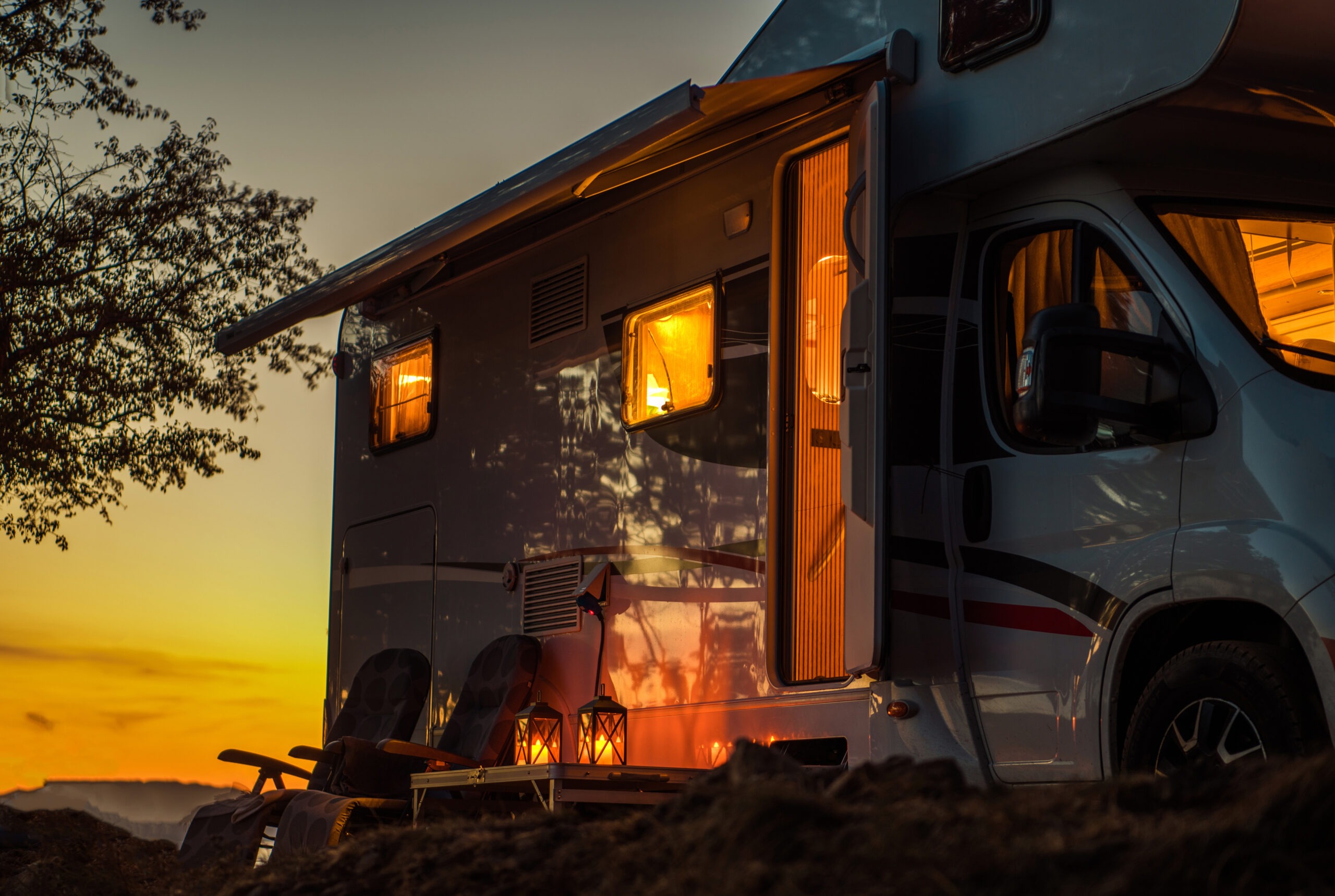 Cozy camper van at sunset, illuminated windows and lanterns create a warm atmosphere, perfect for outdoor relaxation and adventure.